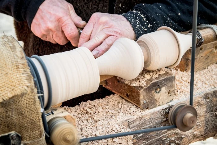 Person drechselt Holz auf Drechselbank